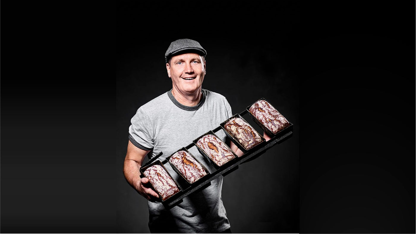 Hans Martin - Bäckermeister Backsüchtig Bäckerei hält frisch gebackene Brotstangen in der Hand. 
