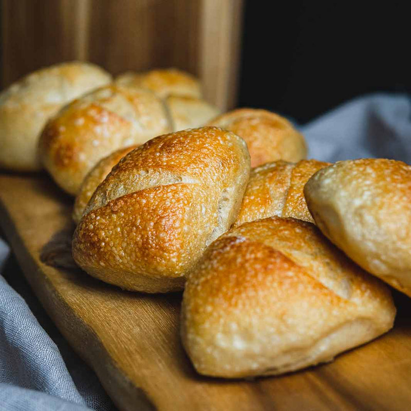 Mini Knautzen - so werden  Sauerteigteigbrötchen aus Weizen in Bielefeld genannt - aufgereiht auf einem Frühstücksbrett